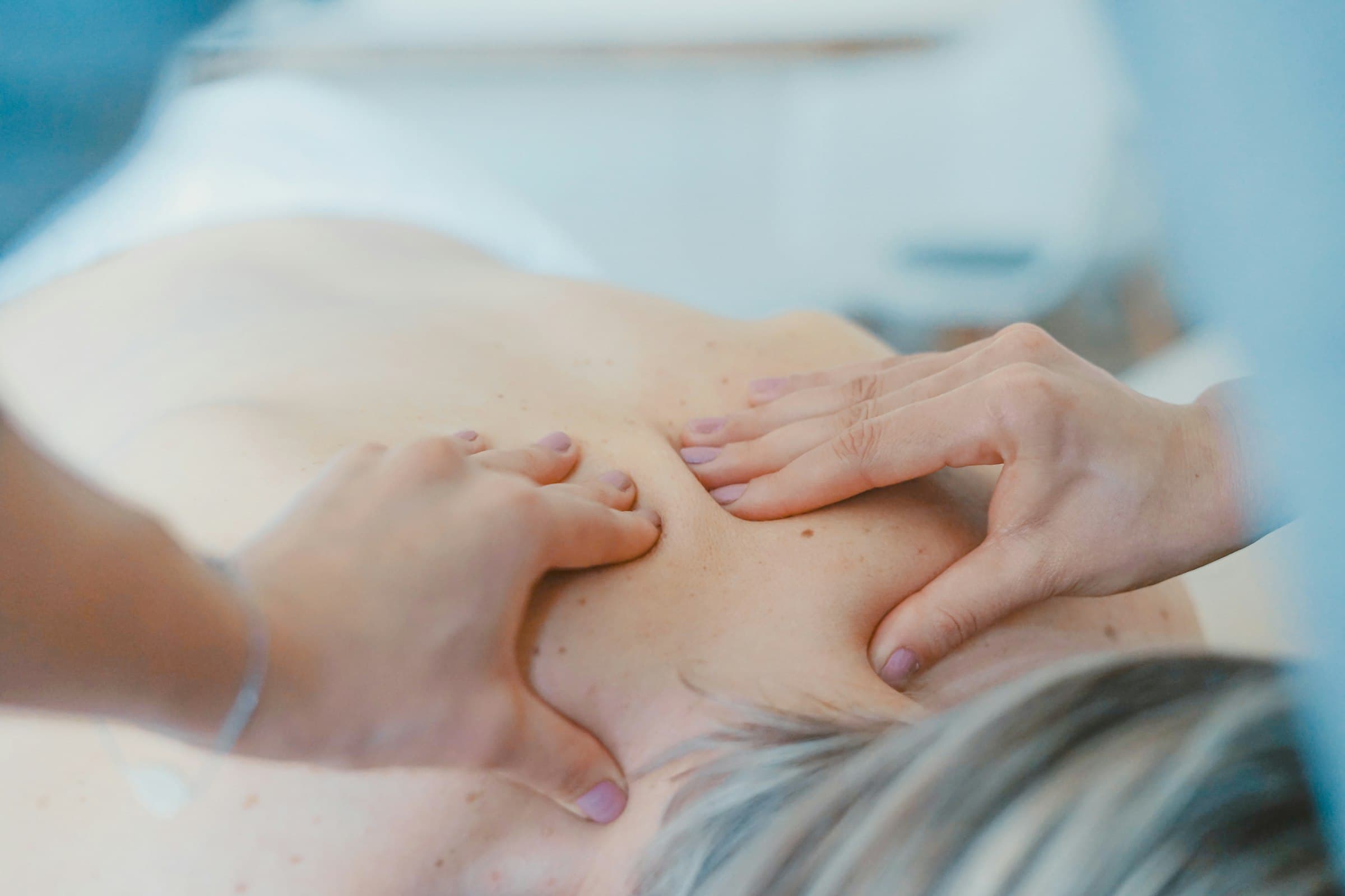 Massage therapist working on a client in a warmly lit studio