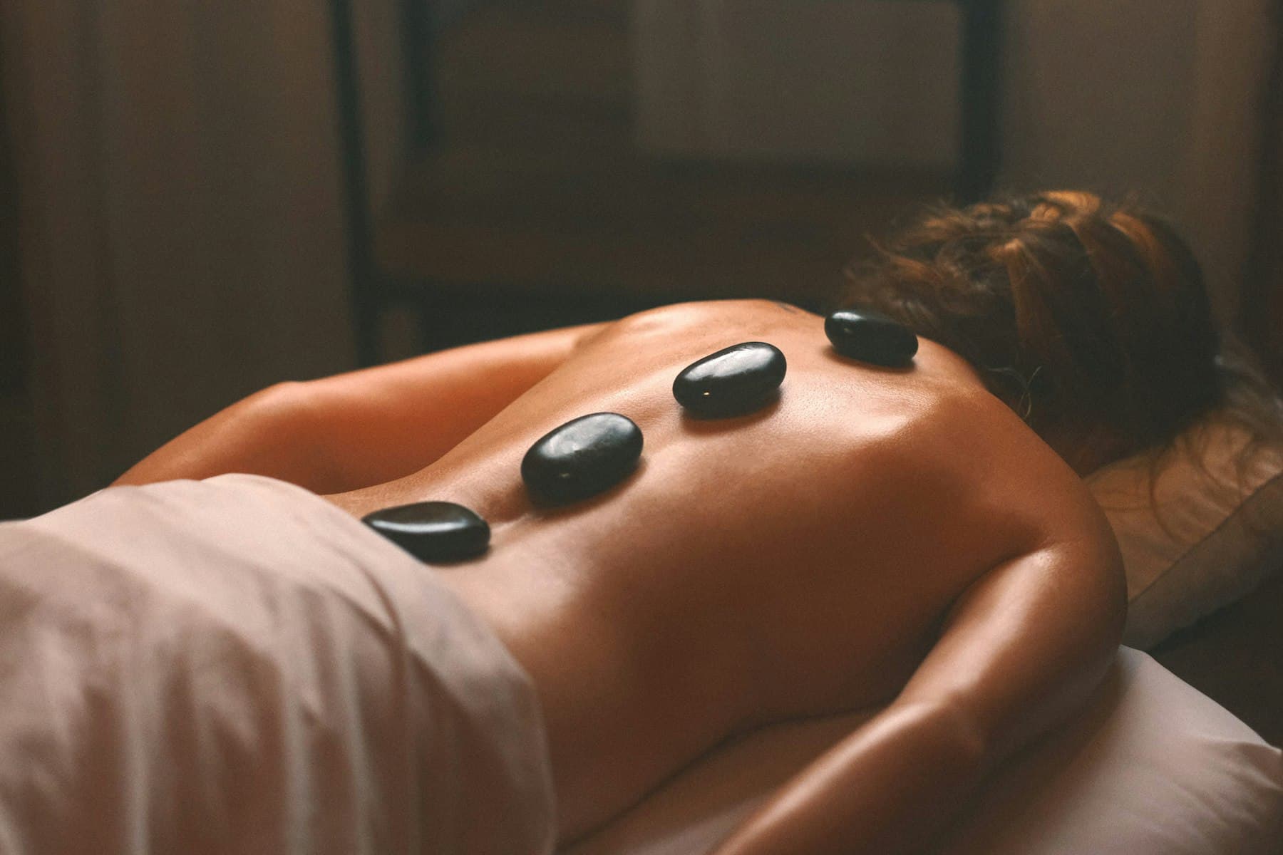 Hot stone massage with heated stones resting on the back